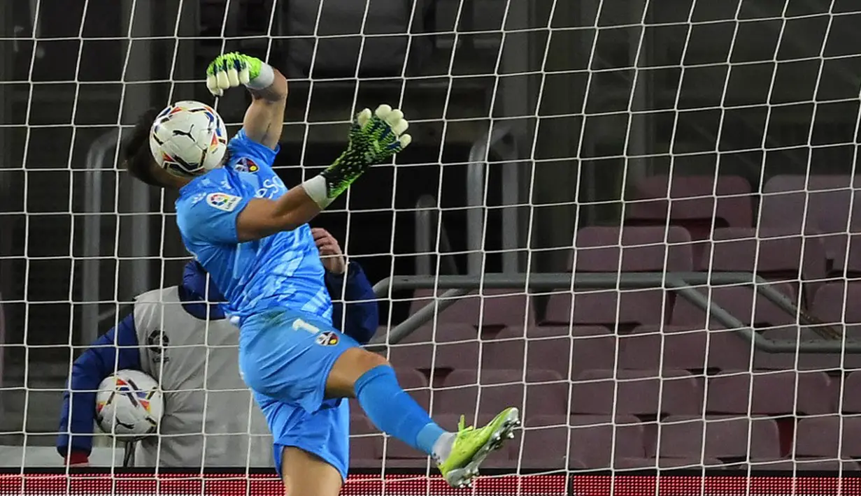 Kiper Huesca Alvaro Fernandez menghentikan bola saat melawan Barcelona pada pertandingan Liga Spanyol di Stadion Camp Nou, Barcelona, Spanyol, Senin (15/3/2021). Barcelona menang 4-1. (LLUIS GENE/AFP)