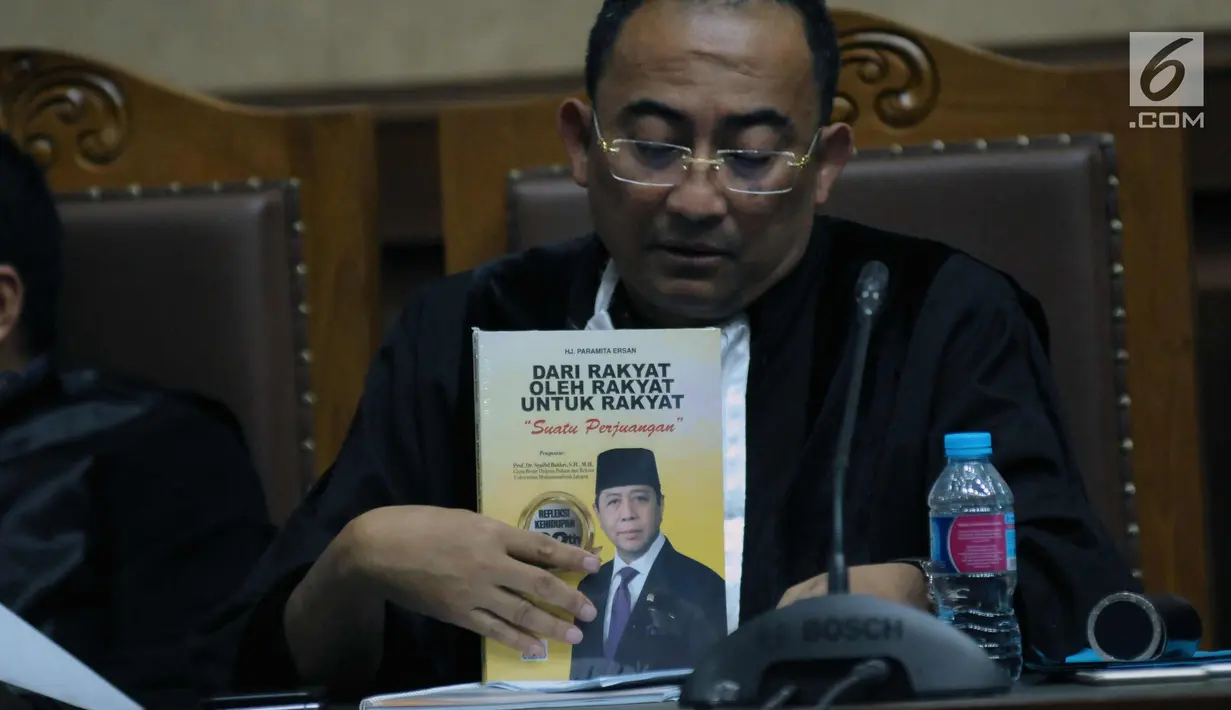 Penasehat hukum Ttrdakwa korupsi proyek e-KTP, Setya Novanto memperlihatkan buku yang dibagikan pada sidang pembacaan nota pembelaan di Pengadilan Tipikor, Jakarta, Jumat (13/4). Sidang mendengar pledoi terdakwa. (Liputan6.com/Helmi Fithriansyah)