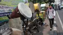 Seorang pria melintas di depan bedug di Jalan KH Mas Mansyur, Tanah Abang, Jakarta, Kamis (31/5). Memasuki pertengahan bulan Ramadan, penjualan bedug mengalami peningkatan. (Liputan6.com/Arya Manggala)