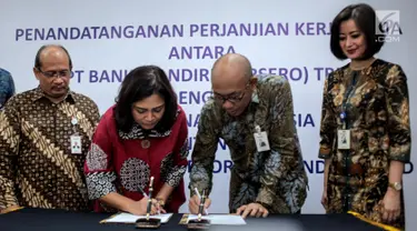 Dirut PT Pelni Insan Purwarisya L Tobing dan Direktur Hubungan Kelembagaan Bank Mandiri Alexandra Askandar menyaksikan Direktur Keuangan PT Pelni Tri Andayani dan SVP Government Institutional Bank Mandiri Dadang Ramadhan menandatangani kerja sama, Jakarta, Rabu (24/7). (Liputan6.com/Faizal Fanani)