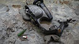 Sebuah skuter tergeletak di lumpur setelah tanah longsor yang disebabkan oleh hujan deras di Khaniyara, dekat Dharmsala, India (2/9/2022). Tidak ada korban jiwa yang dilaporkan akibat musibah tersebut. (AP Photo/Ashwini Bhatia)