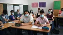 Siswa kelas sebelas dengan masker duduk di ruang kelas sekolah menengah Phoenix di Dortmund, Jerman barat, Rabu (12/8/2020). Para siswa di negara bagian Jerman, North Rhine-Westphalia, harus mengenakan masker setiap waktu ketika mereka kembali ke sekolah pada Rabu ini. (Ina FASSBENDER/AFP)