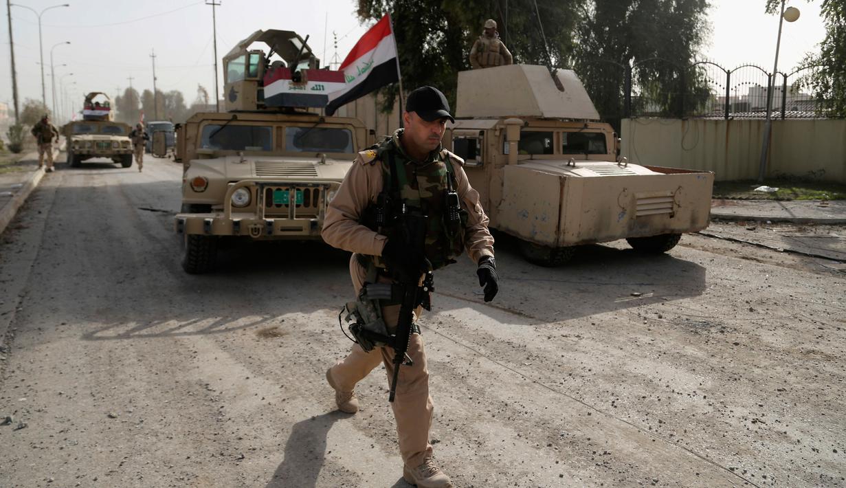 Pasukan Irak menelusuri jalanan selama pertempuran melawan militan ISIS, di sisi timur Mosul, Irak (10/1). Pertempuran dengan militan ISIS kembali terjadi saat pasukan Irak sedang melakukan evakuasi warga Mosul. (AP Photo/Khalid Mohammed)