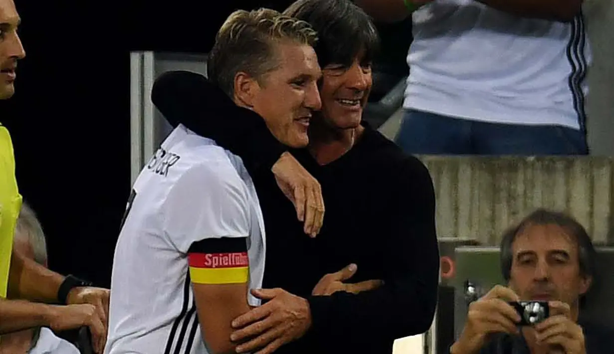 Bastian Schweinsteiger memeluk pelatih Jerman, Joachim Loew usai laga Jerman melawan Finlandia di Monchengladbach, Jerman (1/9/2016) dini hari WIB. Jerman menang 2-0. (AFP/Patrik Stollarz)