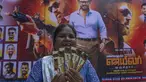 Seorang penggemar memperlihatkan tiket filmnya di dekat poster superstar India Rajinikanth, di luar gedung bioskop untuk merayakan pemutaran film terbarunya "Jailer" di Mumbai, India, Kamis (10/8/2023). (AP Photo/Rafiq Maqbool)