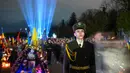Penjaga kehormatan Ukraina berdiri saat pencahayaan simbolis yang disebut "Ray of Memory" terlihat di Pemakaman Lychakiv, Lviv pada 23 Februari 2024. (YURIY DYACHYSHYN/AFP)