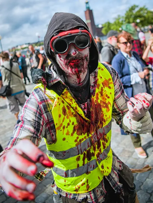 Seorang pria menggunakan kostum seperti zombie berjalan di tengah kota dalam parade "Zombie Walk" di Stockholm, Swedia, Sabtu (19/8). Zombie Walk adalah acara yang rutin dilakukan saat musim panas tiba, tepatnya akhir Agustus. (Jonathan NACKSTRAND/AFP)