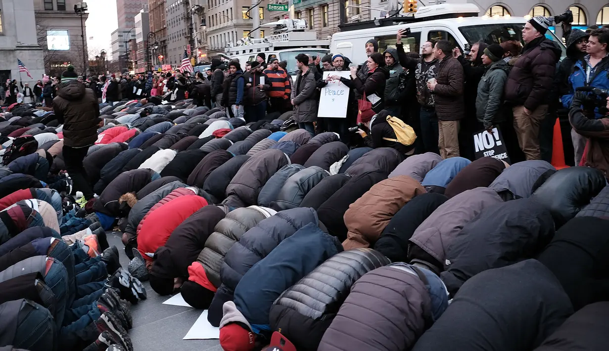 Ratusan pengunjuk rasa melakukan salat berjamaah di New York, AS (2/2). Unjuk rasa dilakukan karena adanya perintah eksekutif Donald Trump yang melarang imigran dan pengungsi dari tujuh negara mayoritas muslim. (Spencer Platt / Getty Images / AFP)