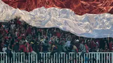 Suporter Timnas Indonesia mengibarkan bendera raksasa saat melawan Thailand pada laga Final Piala AFF 2016 di Stadion Pakansari, Bogor, (14/12/2016). (Bola.com/Nicklas Hanoatubun)