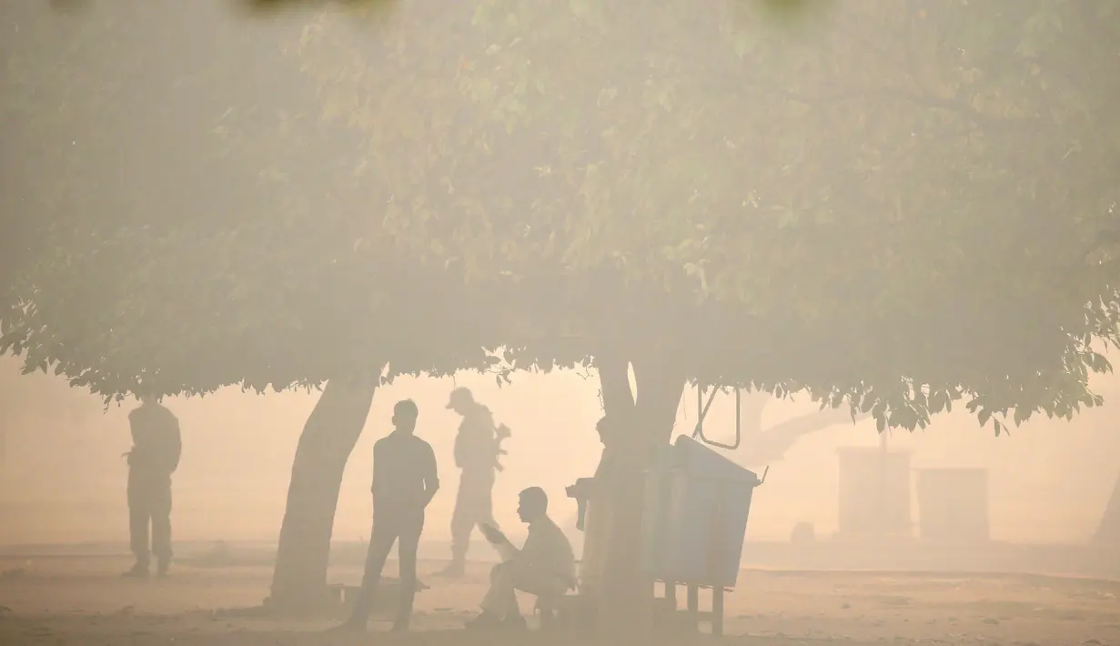Polisi berjaga di sebuah taman umum diselimuti kabut polusi setelah perayaan Diwali di New Delhi, India (31/10). Kabut asap tebal yang menyelimuti Kota New Delhi mengancam kesehatan para warga setempat. (Reuters/Cathal McNaughton)