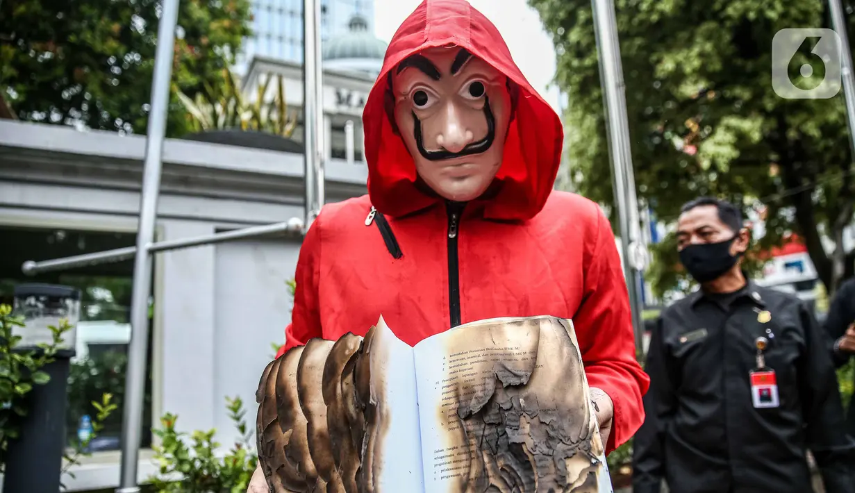 Seorang mahasiswa dari Mahasiswa Independen secara simbolis membakar salinan naskah UU Cipta Kerja di depan Gedung MK, Jakarta, Selasa (27/10/2020). Mahasiswa menyatakan aksi tersebut bentuk ketidakpercayaan kepada MK bila proses uji materi UU Cipta Kerja dilakukan. (Liputan6.com/Faizal Fanani)