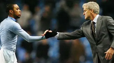 Manchester City&#039;s striker Robinho shakes hands with manager Mark Hughes after winning their Premier League football match against Newcastle at the City Of Manchester Stadium in Manchester on January 28, 2009. AFP PHOTO/Glyn Kirk