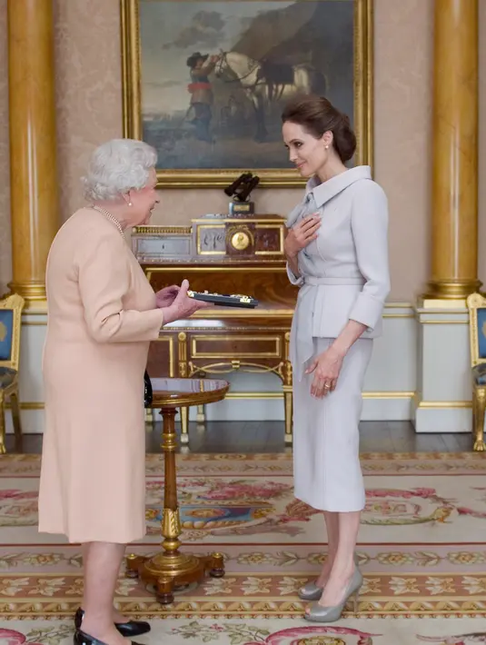 Ini adalah Angelina Jolie di tahun 2014 saat ia bertemu dengan Ratu Elizabeth. Angelina Jolie mengenakan koleksi couture Ralph & Russo bernuansa abu-abu muda. Foto: Website.