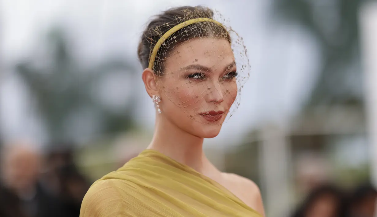 Ia menambahkan aksesori elegan berupa ikat kepala emas tipis dengan kerudung berjaring menutupi wajahnya, memakai mata smokey dan lipstik berwarna terakota. (Photo by Vianney Le Caer/Invision/AP)