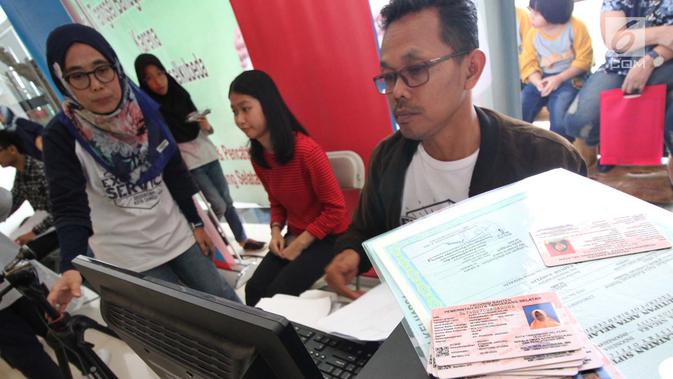 Petugas Disdukcapil Kota Tangerang Selatan melakukan perekaman data untuk pembuatan Kartu Identitas Anak (KIA) di mal Living Wolrd Alam Sutera, Serpong, Senin (17/12). Pusat perbelanjaan ini menggelar pembuatan KIA secara gratis. (Merdeka.com/Demy)