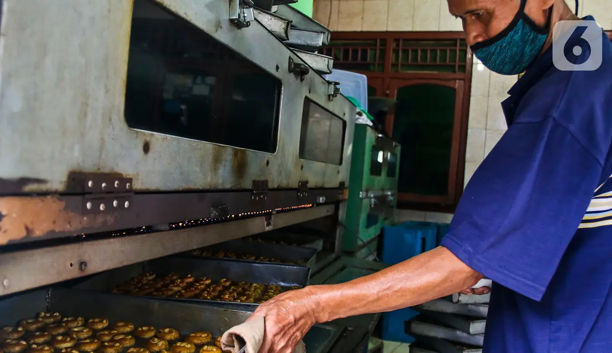 Pekerja memasukkan adonan kue ke oven di industri pembuatan kue kering Pusaka Kwitang, Jakarta, Kamis (30/4/2020). Kue kering yang dijual seharga Rp480 ribu per kaleng itu pada bulan Ramadan tahun ini mengalami penurunan produksi hingga 500 kaleng akibat pandemi COVID-19. (Liputan6.com/Johan Tallo)