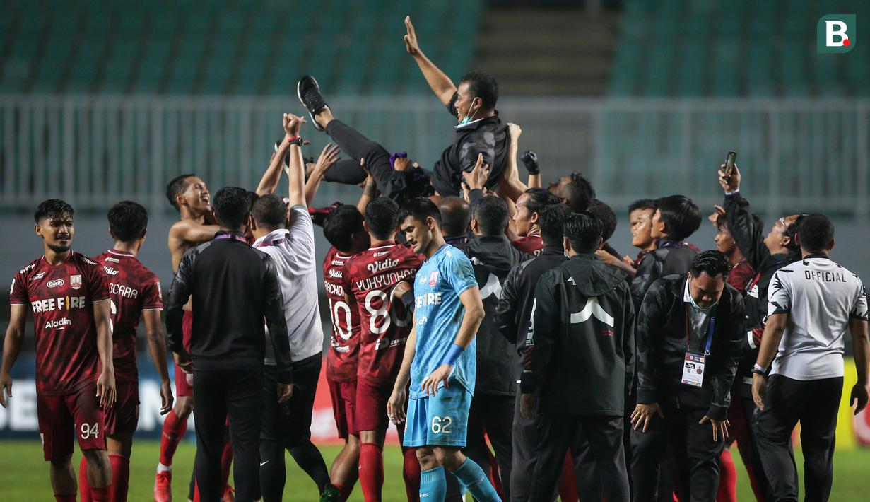 Para pemain dan tim ofisial Persis Solo merayakan kemenangan 2-1 atas Martapura Dewa United dengan mengangkat pelatih Eko Purdjianto usai berakhirnya laga semifinal Liga 2 2021 di Stadion Pakansari, Bogor, Senin (27/12/2021). (Bola.com/Bagaskara Lazuardi)