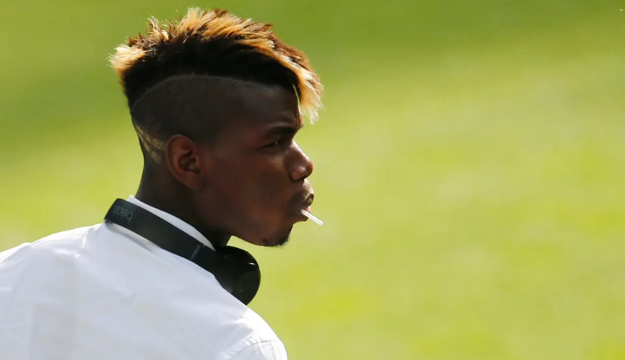 Gelandang Juventus, Paul Pogba terlihat menggigit gagang permen saat menunggu konferensi pers di Stadion Santiago Bernabeu, Spanyol (12/5/2015). Juventus akan menantang Real Madrid di leg kedua semifinal Liga Champions.  (Reuters/Sergio Perez)
