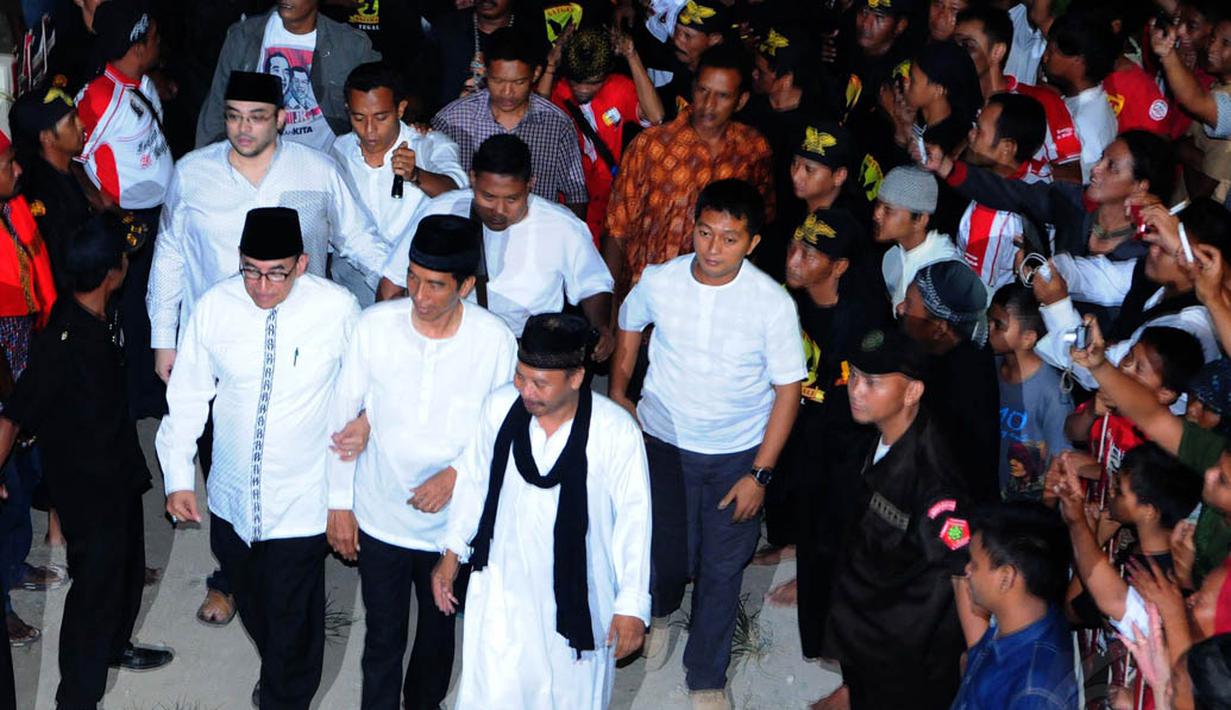 Mantan Wali Kota Solo itu (tengah) didampingi pimpinan ponpes Al-Baghdadi, K.H. Junaedi Al-Baghdadi (kanan) berjalan menuju tempat acara doa bersama, Karawang, Jumat (4/7/14). (Liputan6.com/Andrian M Tunay)