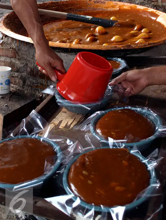 Pekerja mengemas dodol betawi "Ibu Ipah" dalam keranjang, di industri rumahan kawasan Kampung Gedong, Jakarta Timur, Senin (29/6). Produksi dodol Betawi mengalami peningkatan sepuluh kali lipat seiring permintaan jelang Lebaran. (Liputan6.com/Johan Tallo)