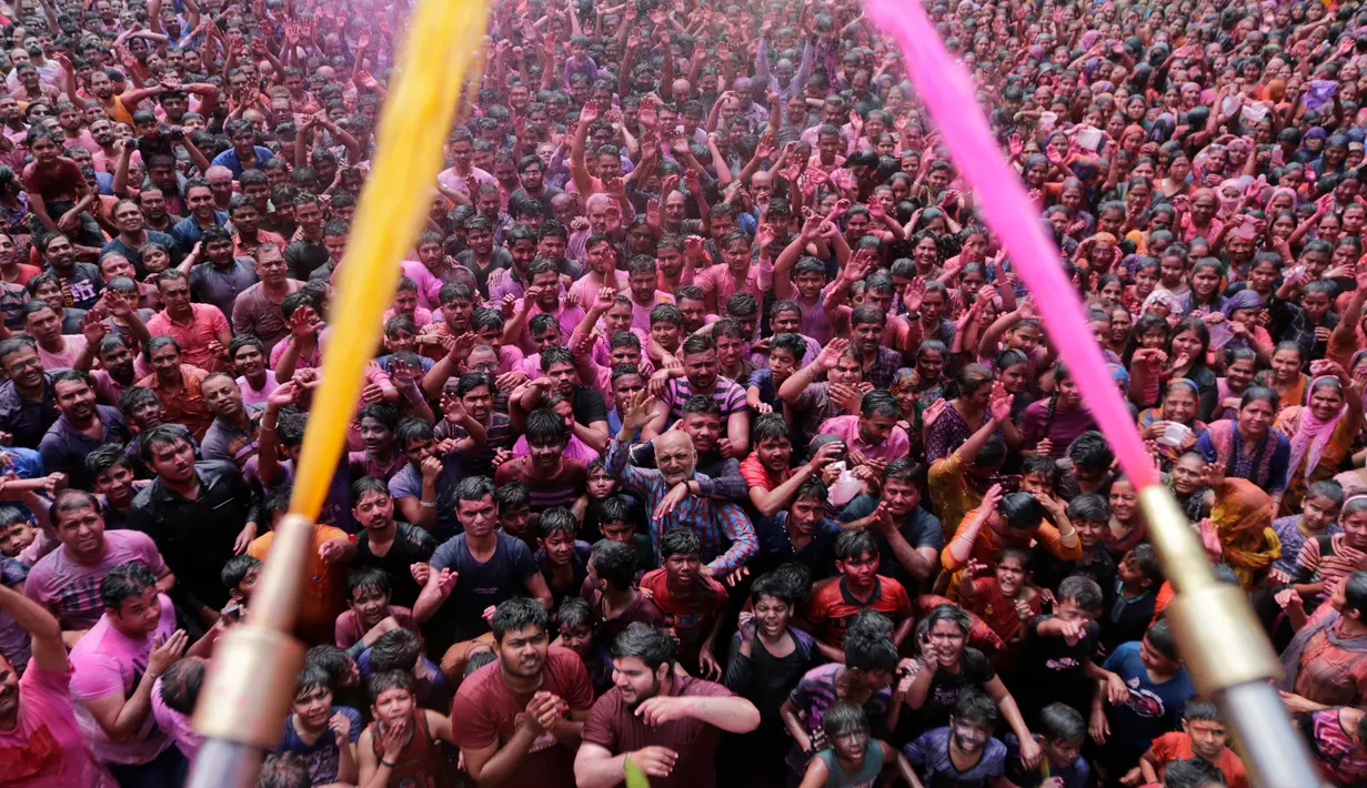 Umat Hindu bersorak ketika bubuk berwarna dan air disemprotkan kepada mereka saat Festival Holi di Kuil Swaminarayan, Ahmedabad, India, Selasa (10/3/2020). Festival Holi menandai datangnya musim semi di India. (AP Photo/Ajit Solanki)