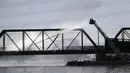 Petugas pemadam kebakaran berupaya memadamkan api saat kereta barang tergelincir dan terbakar di jembatan Danau Kota Tempe, Arizona, Amerika Serikat, Rabu (29/7/2020). Ratusan petugas pemadam kebakaran, polisi, dan paramedis dikerahkan langsung ke lokasi kejadian. (AP Photo/Ross D. Franklin)