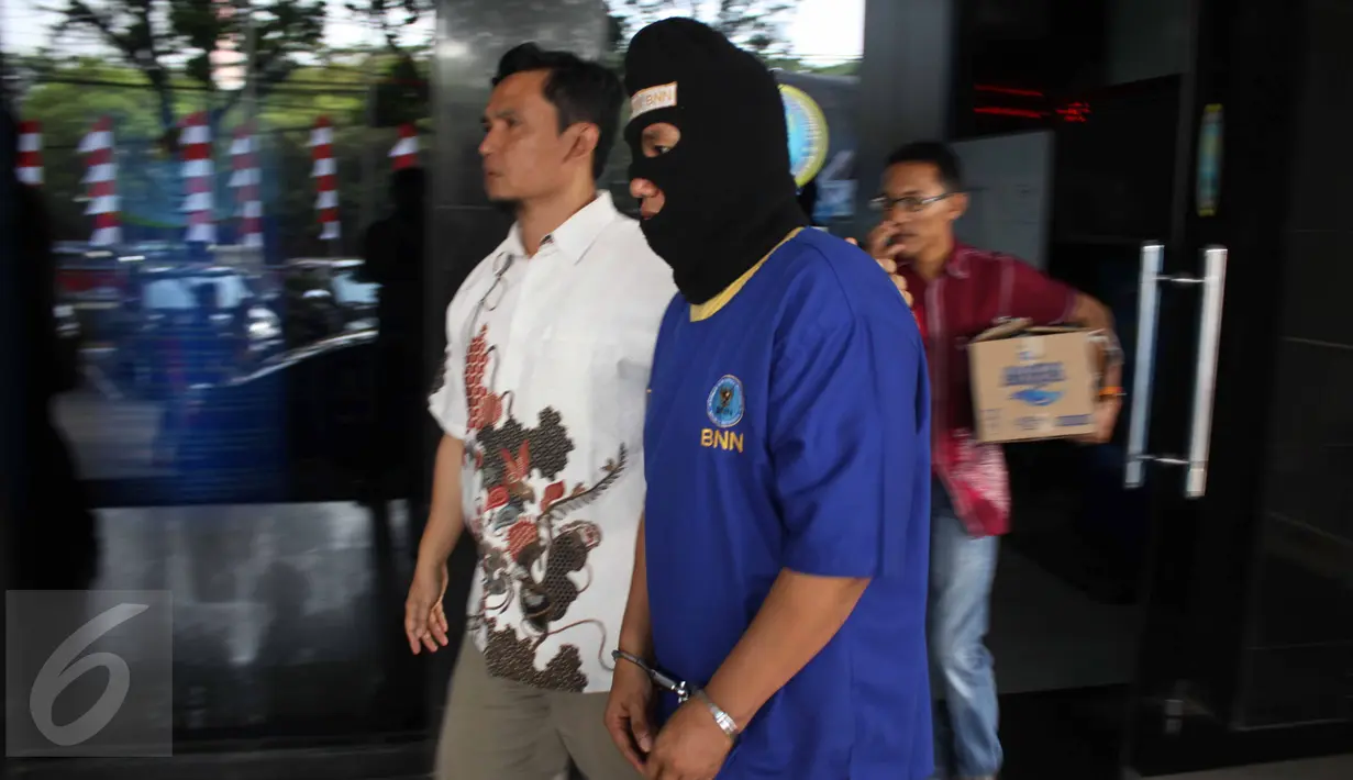 Petugas  BNN membawa tersangka usai rilis kasus pencucian uang hasil bisnis narkotika ke dalam bisnis jual beli kendaraan roda empat di Jakarta, Jumat (21/8/2015). Total aset yang disita diperkitakan mencapai Rp 4,6 miliar.(Liputan6.com/Gempur M Surya)