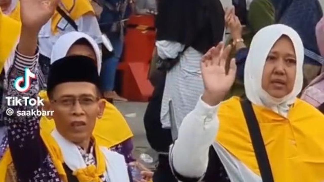 Tak hanya sang ayah, tepat di sampingnya sang ibu juga melambaikan tangan pada anaknya.