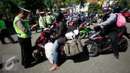 Petugas memeriksa surat pengendara sepeda motor pada operasi lalu lintas di Abu Bakar Ali, Yogyakarta, (19/5). Operasi ini untuk menekan angka kecelakaan, petugas memberikan surat tilang di tempat kepada pelanggar lalu lintas. (Liputan6.com/Boy Harjanto)