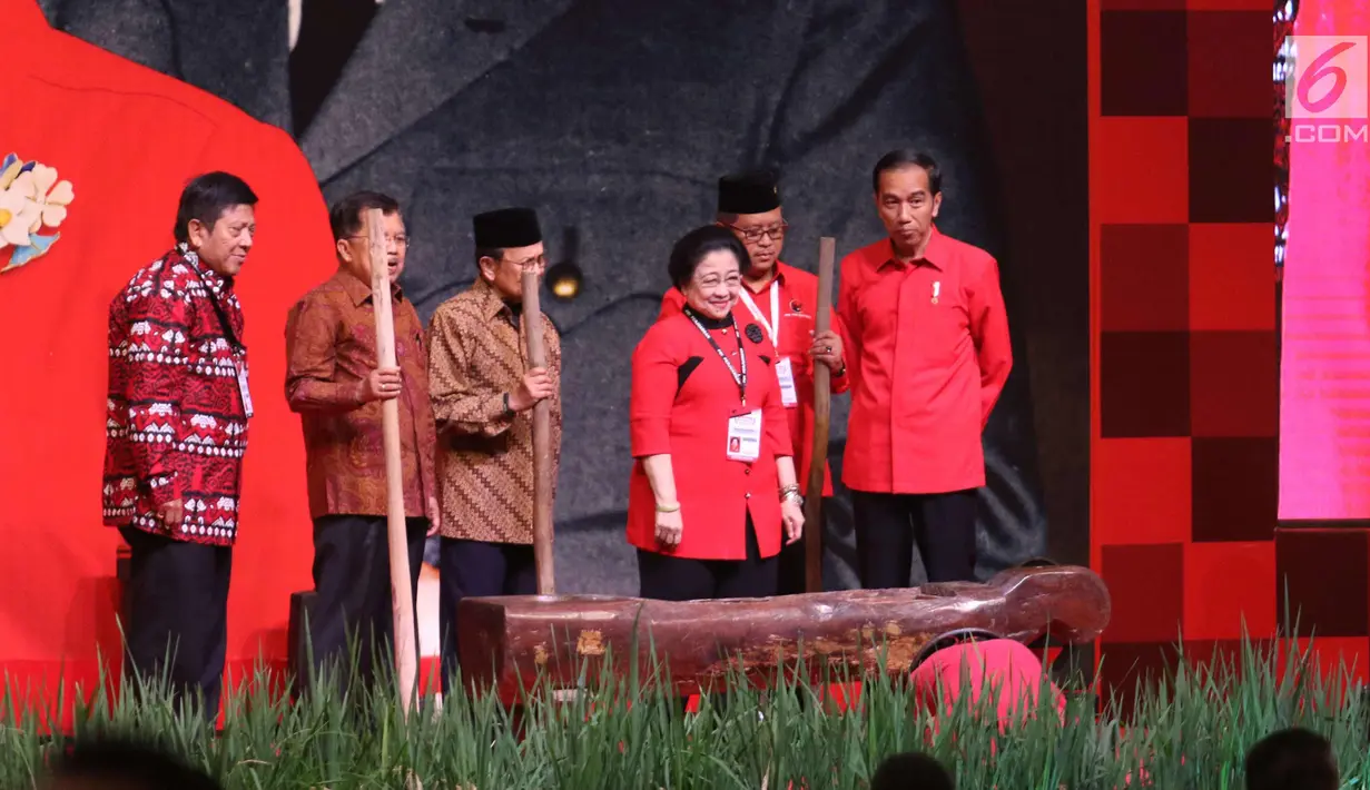 Presiden Jokowi , Wapres Jusuf Kalla, Presiden ke-3 BJ Habibie dan Ketum PDIP Megawati Soekarnoputri bersiap menumbuk padi saat acara Rakornas Tiga Pilar PDI P di ICE BSD, Tangerang Selatan, Sabtu (16/12). (Liputan6.com/Angga Yuniar)