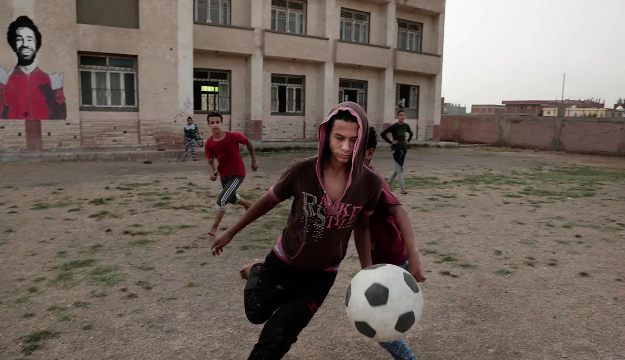 Anak-anak bermain bola di pusat olahraga dan pemuda di Desa Nil Delta Nagrig, Mesir, Rabu (2/5). Bantuan Mohamed Salah ke kampung halamannya tersebar ke sekolah, masjid, pusat pemuda, dan rumah sakit. (AP Photo/Nariman El-Mofty)