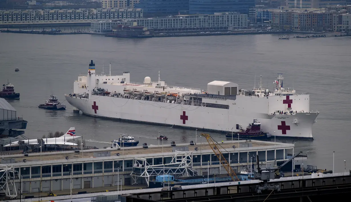 Kapal Rumah Sakit Angkatan Laut USNS Comfort melewati Sungai Hudson saat menuju New York, Amerika Serikat, Senin (30/3/2020). Kapal ini dikerahkan untuk mendukung sistem perawatan kesehatan pasien virus corona COVID-19 di New York. (AP Photo/Craig Ruttle)