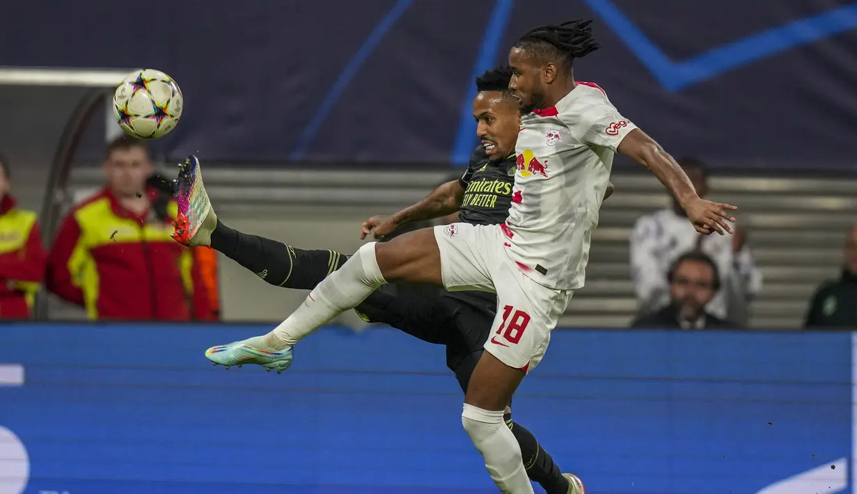 Bek Real Madrid Eder Militao berebut bola dengan penyerang RB Leipzig Christopher Nkunku pada pekan ke-5 Grup F Liga Champions 2022/2023 di Red Bull Arena, Rabu (26/10/2022) dinihari WIB. Bermain tanpa Karim Benzema dan Luka Modric, Real Madrid kesulitan merusak pertahanan RB Leipzig. (AP Photo/Matthias Schrader)