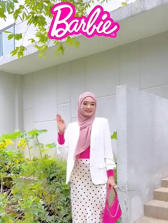 Untuk tampilan formal, Inara memadukan long sleeve top berwarna fuschia dengan blazer putih dan rok polkadot putih. Penampilannya dilengkapi hijab baby pink, beserta handbag dan heels warna fuschia. [Instagram/inararusli].