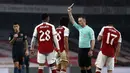 Gelandang Arsenal, Mohamed Elneny (tengah), menerima kartu kuning dari wasit Stuart Atwell dalam laga perempatfinal Piala Liga Inggris Carabao Cup melawan Manchester City di Emirates Stadium, London, Selasa (22/12/2020). Arsenal kalah 1-4 dari Manchester City. (AFP/Adrian Dennis)