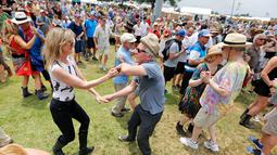 Sejumlah penonton berdansa menikmati musik selama New Orleans Jazz and Heritage Festival di Fair Grounds di New Orleans , AS (25/4). (Ted Jackson / NOLA.com Times-Picayune via AP)