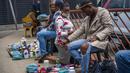 Seorang wanita berkonsultasi dengan dokter tradisional di dekat pangkalan taksi Baragwanath di Soweto, Afrika Selatan, Kamis (2/12/2021). Afrika Selatan mempercepat kampanye vaksinasi untuk memerangi lonjakan pesat kasus Covid-19 usai mendeteksi varian Omicron pekan lalu. (AP Photo/Jerome Delay)