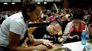 Seorang instruktur Kuba (kiri) membantu peserta menggulung cerutu selama kelas master dalam Festival Havana Cigar ke-20 di Istana Konvensi di Havana, Kuba (28/2). (AFP Photo/Adalberto Roque)