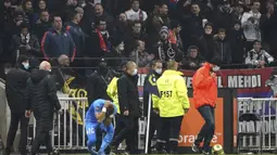 Payet pun langsung memegang bagian kepalanya yang terkena botol. (AP Photo/Laurent Cipriani)