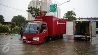Mobil pompa penyedot air Dinas Tata Air dikerahkan untuk menyedot air banjir yang merendam Jalan Gunung Sahari, Jakarta, Selasa (21/2). Hujan yang mengguyur sejak Selasa dinihari membuat sebagian wilayah di Jakarta banjir. (Liputan6.com/Faizal Fanani)