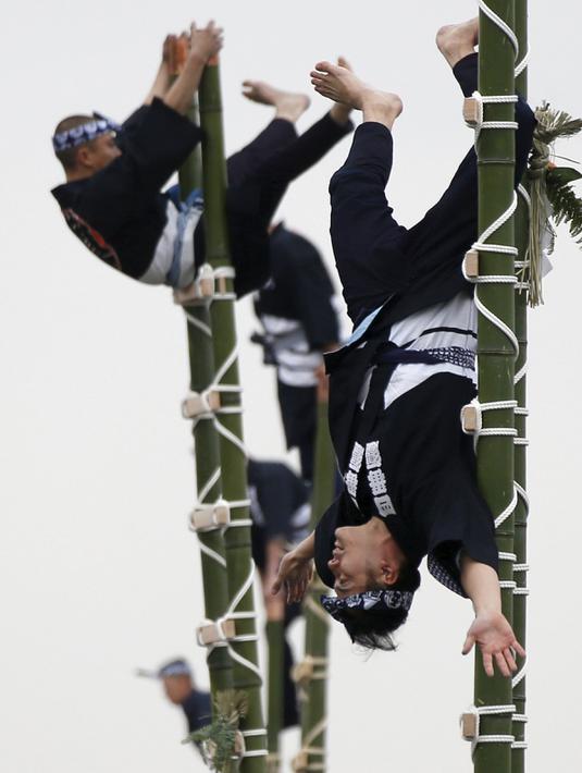 Anggota perkumpulan Edo saat menampilkan atraksi diatas ujung bambu di Tokyo, Jepang, (6/1). Atraksi ini dilakukan oleh para petugas pemadam kebakaran Tokyo.( REUTERS / Yuya Shino)