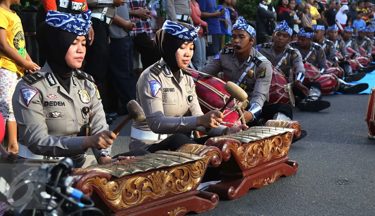 Sejumlah polisi wanita (polwan) memainkan alat musik tradisional, gamelan, pada kegiatan car free day di Jakarta, Minggu (9/4). Dalam atraksi tersebut mereka melakukan sosialisasi “Polwanku Sahabatku”. (Liputan6.com/Angga Yuniar)
