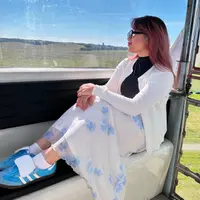 Potret lainnya memperlihatkan Zara yang tampil dengan feminin dengan cardigan putihnya, top hitam, dan maxi skirt motif floral. Penampilannya dilengkapi dengan sneakers warna biru senada dengan roknya. [@ataliapr/@camilliazr].