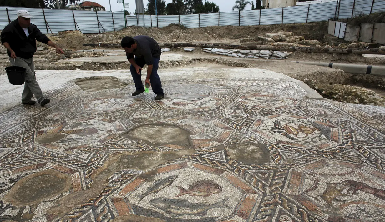 Seorang peneliti sejarah kuno membersihkan sebuah gambar yang ada pada lantai sebuah peradaban pada 1.700 tahun yang lalu di Tel Aviv, Israel, Senin (16/11/2015). Dulunya kota ini merupakan kota yang makmur. (REUTERS/Nir Elias)