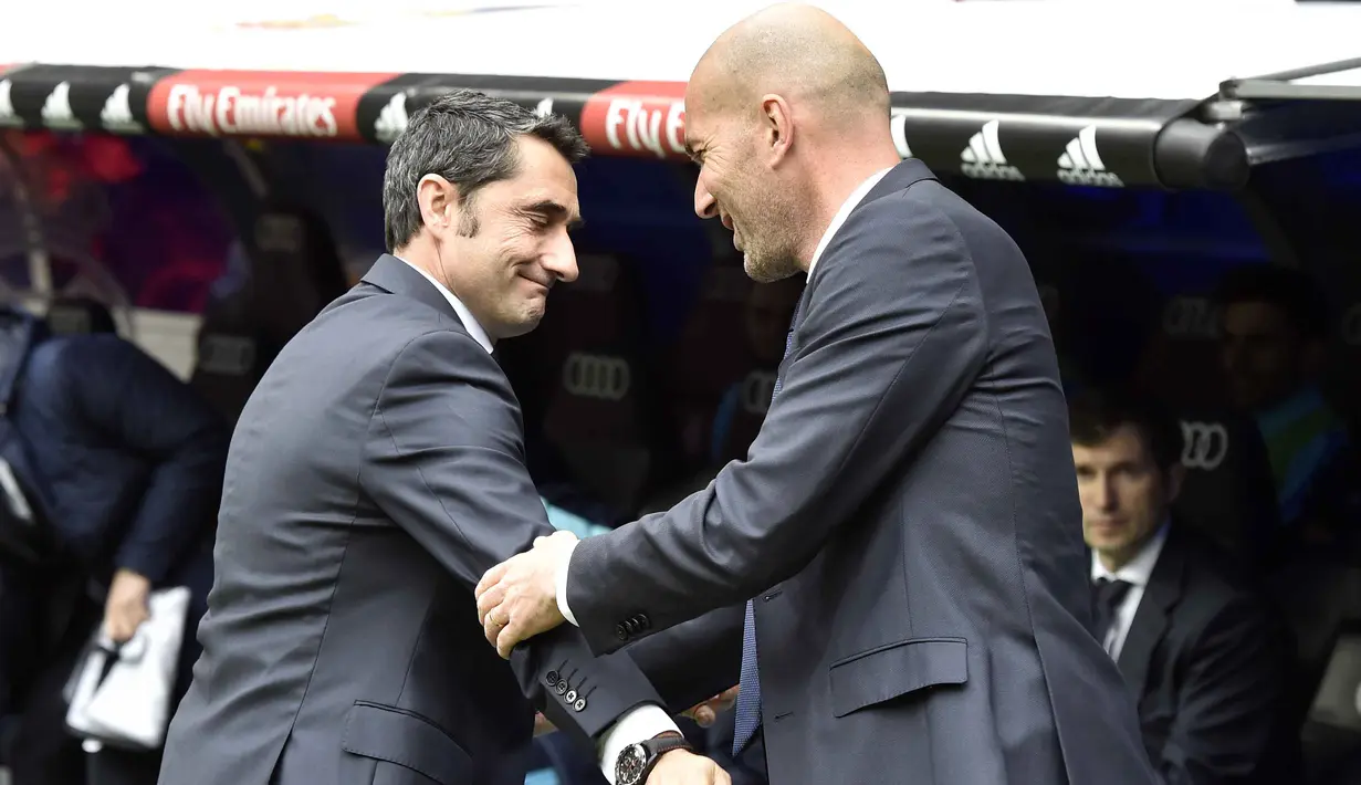 Pelatih Athletic Bilbao, Ernesto Valverde (kiri) bersalaman dengan pelatih Real Madrid,  Zinedine Zidane sebelum laga La Liga Spanyol pekan ke-24 di Stadion Santiago Bernabeu,  Madrid, Sabtu (13/2/2016). (AFP / Gerard Julien)