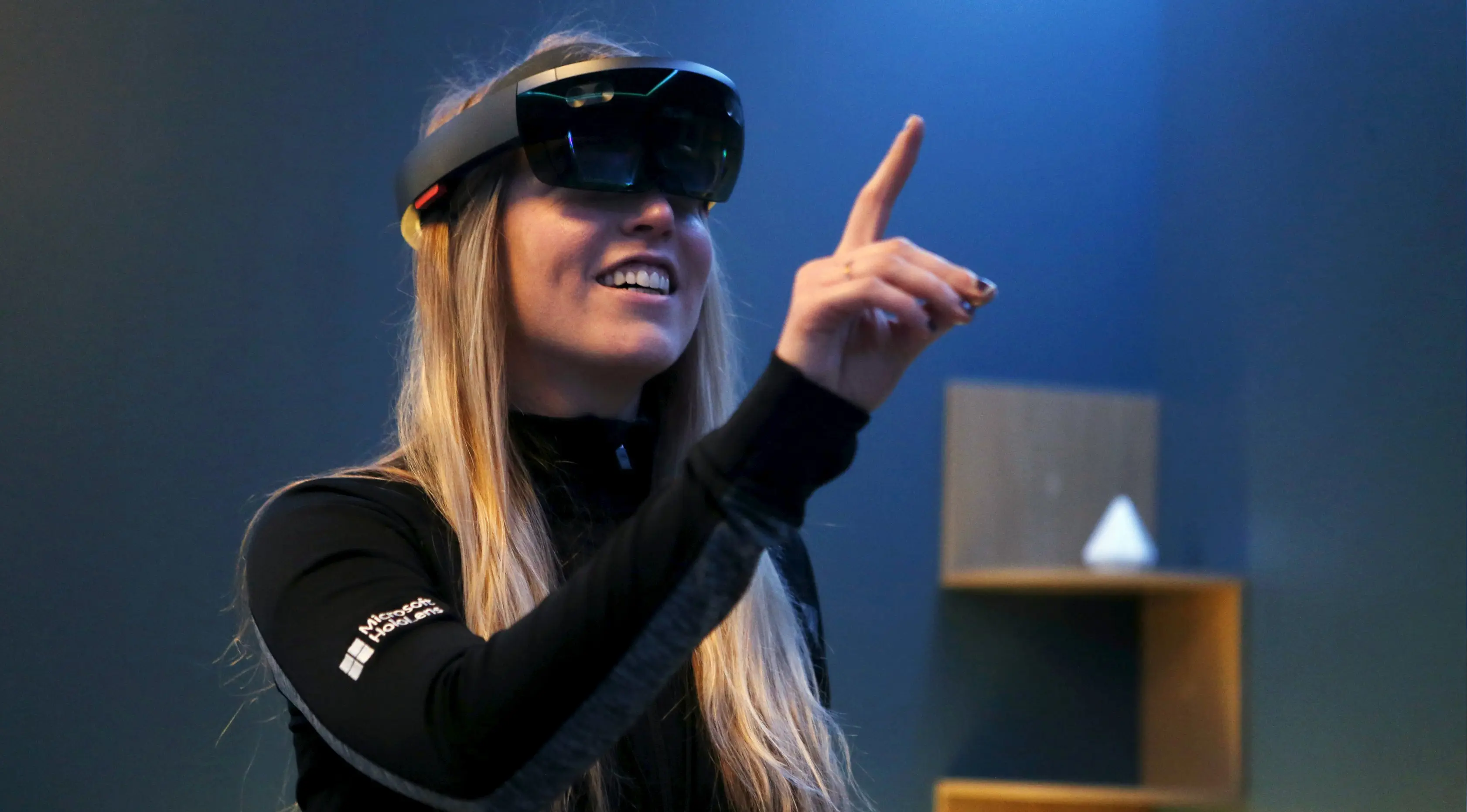 Pegawai Microsoft tersenyum saat memakai HoloLens selama Microsoft Build 2016 Developers Conference di San Francisco, California (30/3).  Dengan mengunakan HoloLens pemakai seperti 'berkunjungan' di beberapa situs di Mars. (REUTERS/Beck Diefenbach)