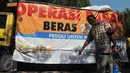 Seorang warga tampak membawa karung beras, Jakarta, Minggu (21/6/2015). Operasi Pasar diluncurkan Kemendag untuk membantu warga mendapatkan beras dan daging murah saat Ramadan. (Liputan6.com/Herman Zakharia)
