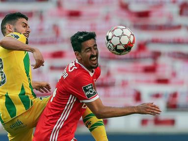Bek Benfica, Andre Almeida, berebut bola dengan bek Tondela, Yohan Tavares, pada laga Liga Portugal di Stadion The Luz, Lisbon, Kamis (4/6/2020) waktu setempat. Kompetisi Liga Portugal resmi dilanjutkan dengan aturan tanpa penonton di setiap pertandingan. (AFP/Tiago Petinga/pool)