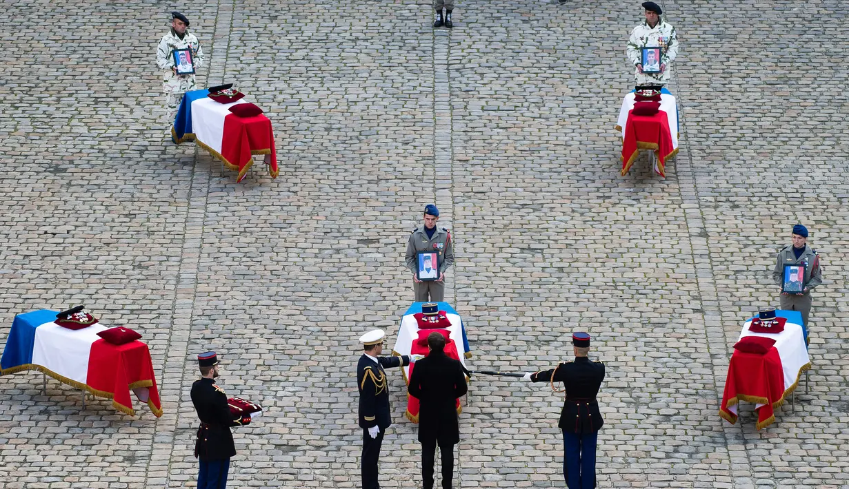 Presiden Prancis Emmanuel Macron (tengah) secara anumerta memberikan penghargaan Legiun Kehormatan kepada salah satu dari 13 tentara Prancis yang tewas dalam kecelakaan helikopter di Mali, Paris, Senin (2/12/2019). (Eliot Blondet/Pool via AP)