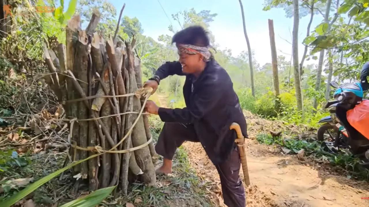 Meski sudah terkenal, Encuy tak meninggalkan kebiasaannya saat berada di kampung halaman. Dia pun tampak mengangkut kayu-kayu bakar di atas bahunya.